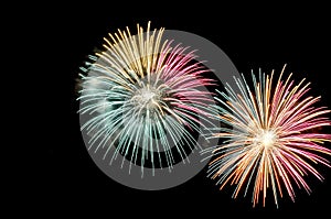 Flashes of multicolored fireworks on black background