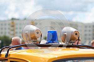 Flashing lights and sirens on the roof of an old police car