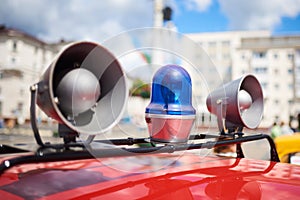 Flashing lights and sirens on the roof of an old police car