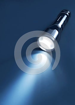 Flashlight and beam of light on a dark background