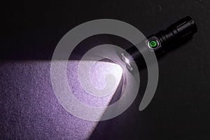 Flashlight and beam of light on a dark background