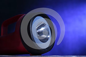Flashlight, close up, under dark blue background with light beam