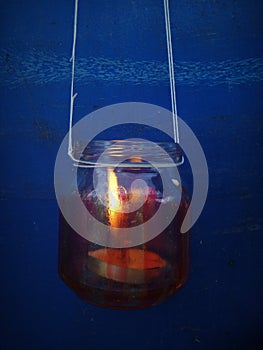 Flashlight with his hands from a small glass jar