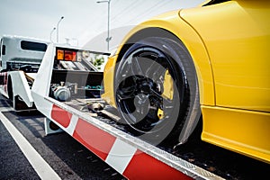 Flat bed tow truck loading a broken vehicle