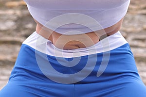 Flat belly girl during diaphragmatic breathing exercises bodyflex on the rock background. Belly close-up view.