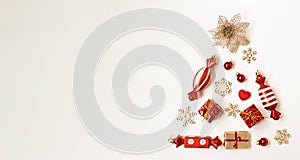 Flat composition with a Christmas tree made of different festive items, snowflakes, gifts, sweets on a white background