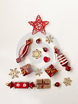 Flat composition with a Christmas tree made of different festive items, snowflakes, gifts, sweets on a white background