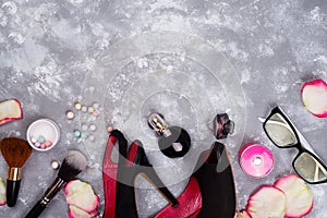 Still life of fashion woman. Women`s fashion with petals of roses, cosmetics, glasses and shoes on stone background photo
