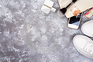 Still life of fashion woman. Women`s fashion with petals of roses, cosmetics, phone and shoes on stone background, copy photo