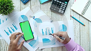 flat composition of man hand with pen analyzing bar chart and using smart phone