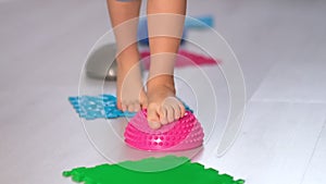 Flat feet physical therapy. child with a flat-bottomed stomach goes barefoot on an orthopedic foot mat for the