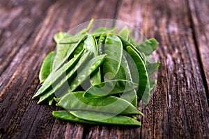 Flat green beans on rustic wooden background