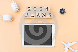 Flat lay of 2024 Plans letter on wooden cube. New year planning and traveling concept. Copy space, top view