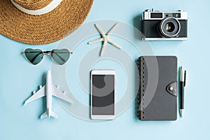 Flat lay of accessories and travel items on blue desk. Summer, holiday and planning a trip concepts. Top view, copy