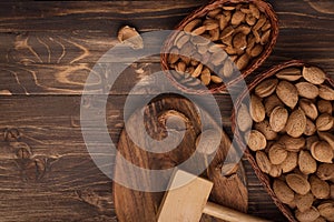 Flat lay of almonds in the wicker plates with other accessories on brown wooden background top view 5