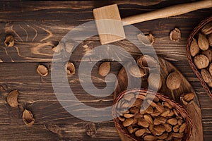 Flat lay of almonds in the wicker plates with other accessories on brown wooden background top view 9