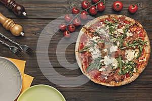 Flat lay with arranged italian pizza, cutlery andcherry tomatoes