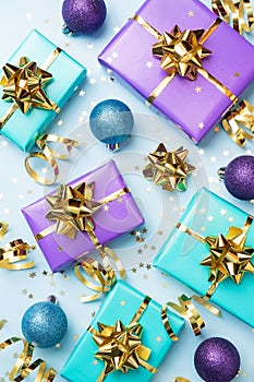 Flat lay background for celebration Christmas and New Year. Gift boxes are purple and turquoise with gold ribbons bows and