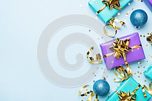 Flat lay background for celebration Christmas and New Year. Gift boxes are purple and turquoise with gold ribbons bows and