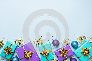 Flat lay background for celebration Christmas and New Year. Gift boxes are purple and turquoise with gold ribbons bows and