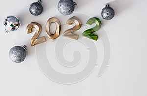 Flat lay background happy new year 2022, golden numbers 2022, silver christmas balls with copy space