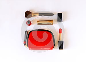 Flat lay of beauty cosmetic make up products in red, black and gold color knolled on white background.