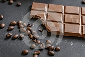 Flat lay of bitten chocolate bar on dark surface f
