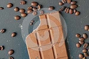 Flat lay of bitten chocolate bar on dark surface f