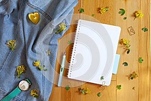 Flat lay of blank notepad, a pen, a watch and yellow barberry flowers