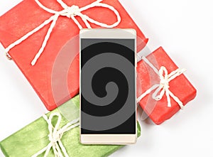 Flat lay of blank screen mobile phone,on red and red  gift box on white background with copy space.Seasonal and holiday,