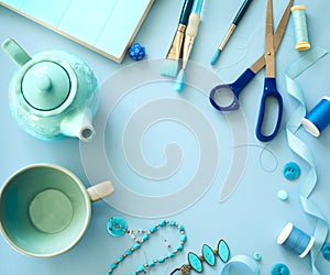 Flat lay blue color objects and accessories frame on light blue background