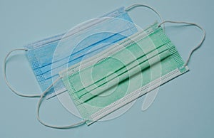 Flat lay of blue and green medical mask for Covid-19 prevention