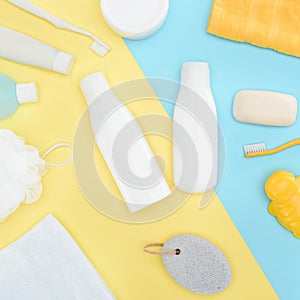 Flat lay with body lotion in bottles, toothbrushes, pumice, towel and soap