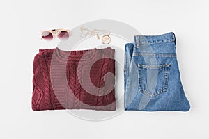 flat lay with burgundy knitted sweater, trendy jeans and accessories,