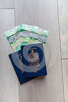 Flat lay canadian passports with canadian money on a neutral wooden background