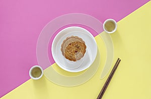 Flat lay of Chinese Festival dessert, Mid- Autumn Festival Moon cake on colorful background with teas and chopsticks.