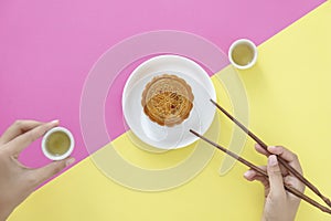 Flat lay of Chinese Festival dessert, Mid- Autumn Festival Moon cake on colorful background with teas and chopsticks.