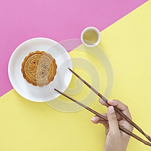 Flat lay of Chinese Festival dessert, Mid- Autumn Festival Moon cake on colorful background with teas and chopsticks.