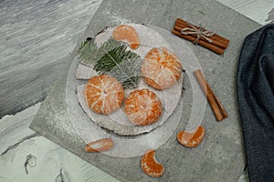 Flat lay Christmas composition with fresh tangerines and fir tree branches on grey background. Space for text
