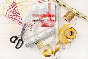 Flat lay of Christmas gifts, decoration paper, ribbons and scissors. Christmas gift concept