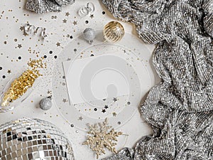 Flat lay of Christmas or New year party disco ball, dress, season decoration and empty white postcard on white background