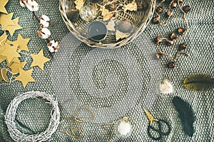 Flat-lay of Christmas toys, garlands, lights, wreath over grey blanket