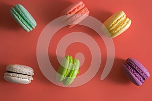 Flat lay. Close up. Sweet colorful french macarons color laid out on the edge. Background color living coral 2019