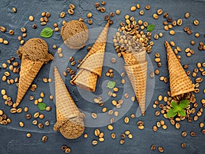 Flat lay coffee ice cream in waffle cone on dark stone background . Homemade coffee ice cream  with coffee beans for sweets menu