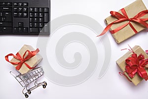 Flat lay collage of keyboard, cardholder in shopping cart and gift boxes isolated on white background. Order gift online on