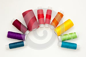 Flat lay with colorful cotton thread spools, embroidery yarn, rainbow bobbins, mock up, top view. Layout mockup on blank white