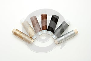 Flat lay colorful cotton thread spools, embroidery yarn, white, brown, gray, black, silver, gold bobbins, mock up, top view.