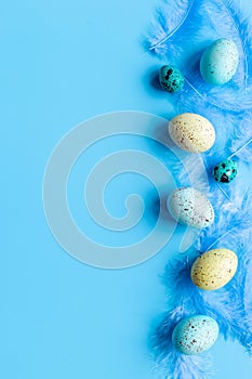 Flat lay of colorful Easter eggs and birds feather, top view