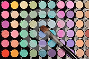 Flat lay of colorful eyeshadow palette with brush