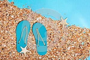 Flat lay of composed miniature of beach lounge area, small sea stars, summer flip-flops